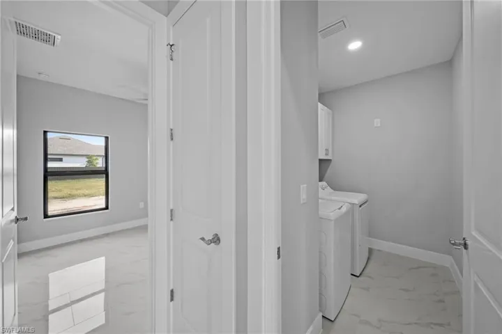 Clothes washing area with washer and dryer and cabinets