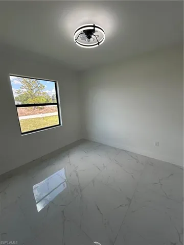 Spare room with marble finish floor and baseboards