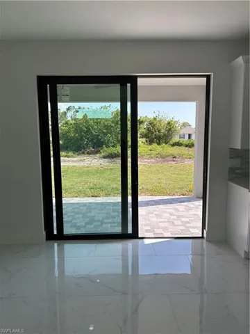 Doorway with marble finish floor and baseboards