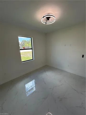 Unfurnished room with marble finish floor and baseboards