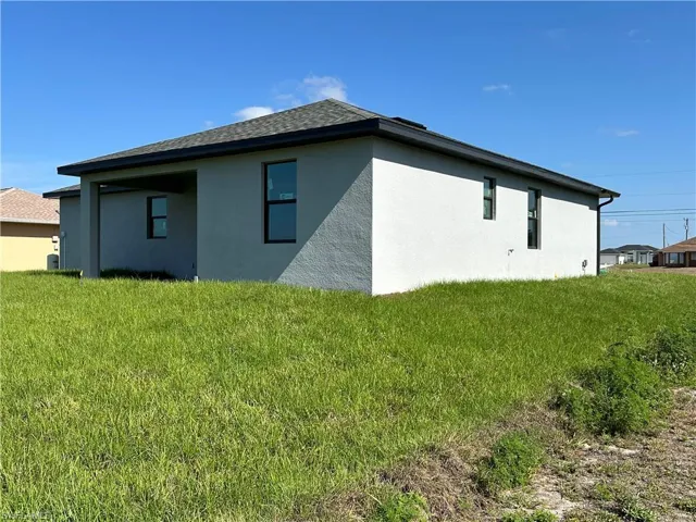 View of home's exterior featuring stucco siding and a lawn