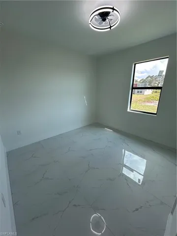 Spare room featuring baseboards and marble finish floor