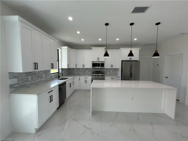 Kitchen with marble finish floor, a sink, stainless steel appliances, and visible vents