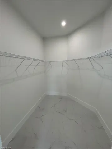 Walk in closet featuring marble finish floor