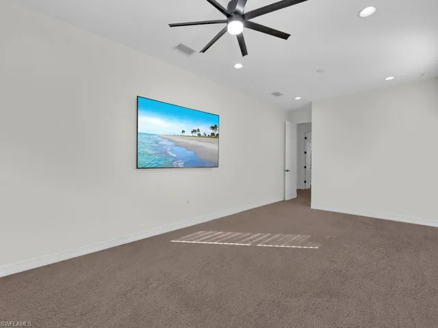 Carpeted spare room featuring ceiling fan and recessed lighting