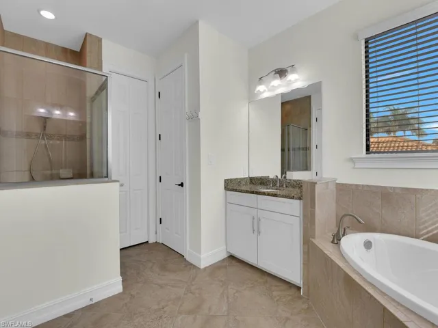 Bathroom with a closet, a shower stall, a bath, and vanity