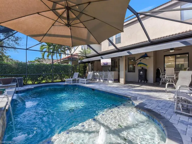 View of pool with a lanai, a sunroom, patio surround, and outdoor dining space