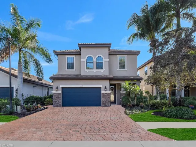 Mediterranean / spanish-style house with an attached garage, stone siding, decorative driveway, stucco siding, and a tile roof