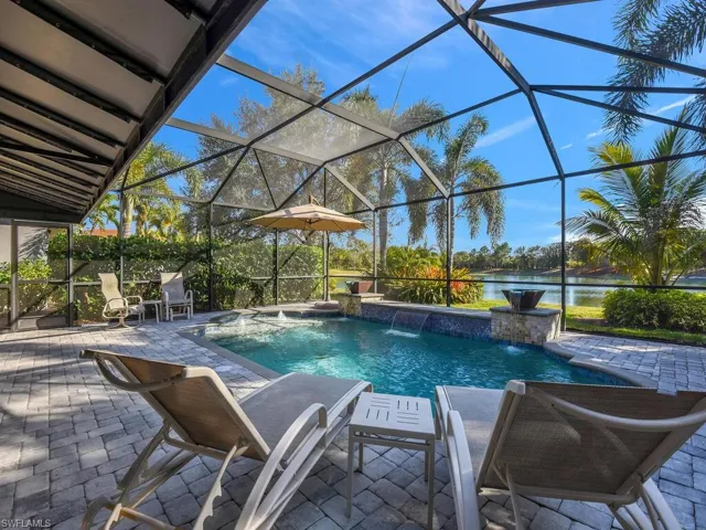 Swimming pool featuring a patio, a sunroom, glass enclosure, and a water view
