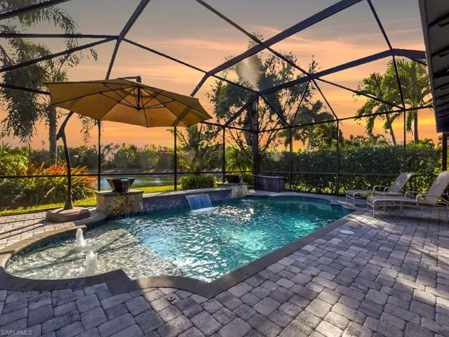 Outdoor pool with glass enclosure, a sunroom, and a patio area