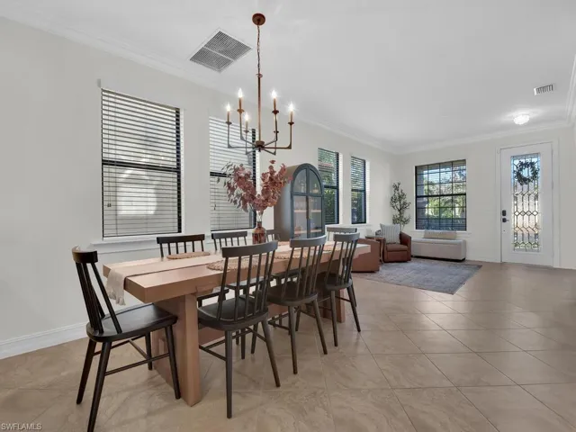 Dining room featuring ornamental molding, a chandelier, and light tile patterned floors