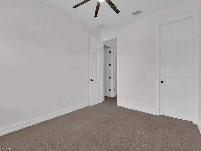 Unfurnished bedroom with carpet and a ceiling fan