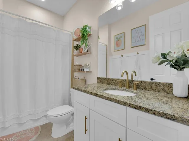 Bathroom featuring vanity and shower / bathtub combination with curtain