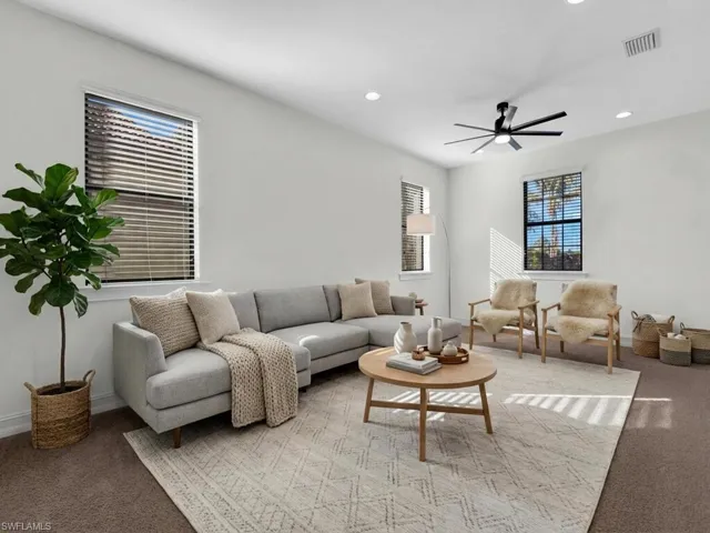 Carpeted living room featuring a ceiling fan and recessed lighting