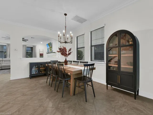 Dining room with ornamental molding, hanging lights, and a ceiling fan