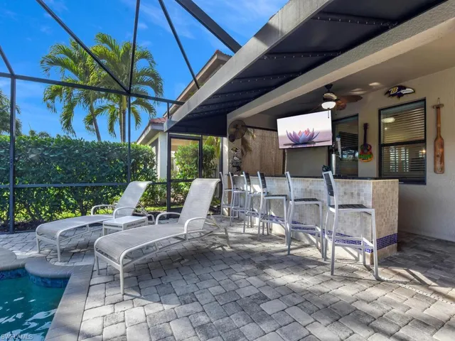 View of patio / terrace with a bar, a lanai, a sunroom, and ceiling fan
