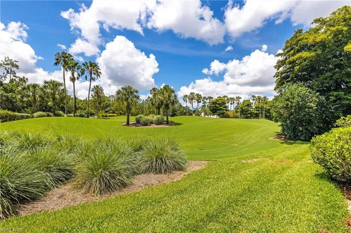Expansive green space featuring manicured lawns and mature tropical landscaping
