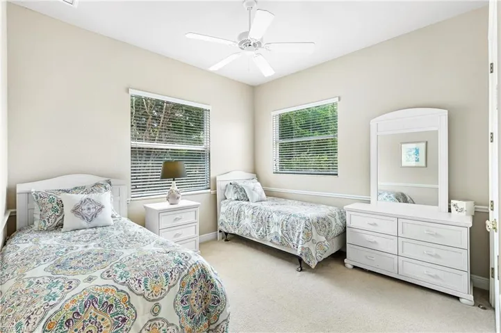 Upstairs Bedroom featuring neutral wall paint, carpet flooring, a ceiling fan, and two windows with horizontal blinds
