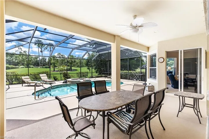 Screened lanai featuring a built-in swimming pool, integrated spa, and an expansive paved deck