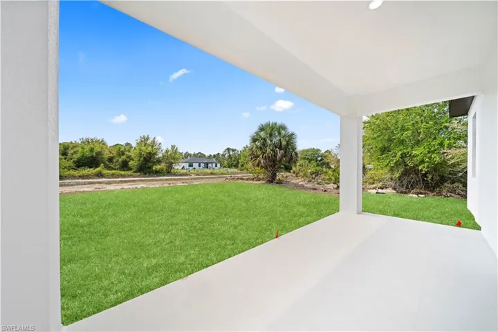 View of green lawn with a patio area