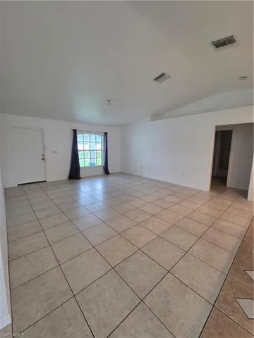 Expansive interior space featuring tile flooring and white walls