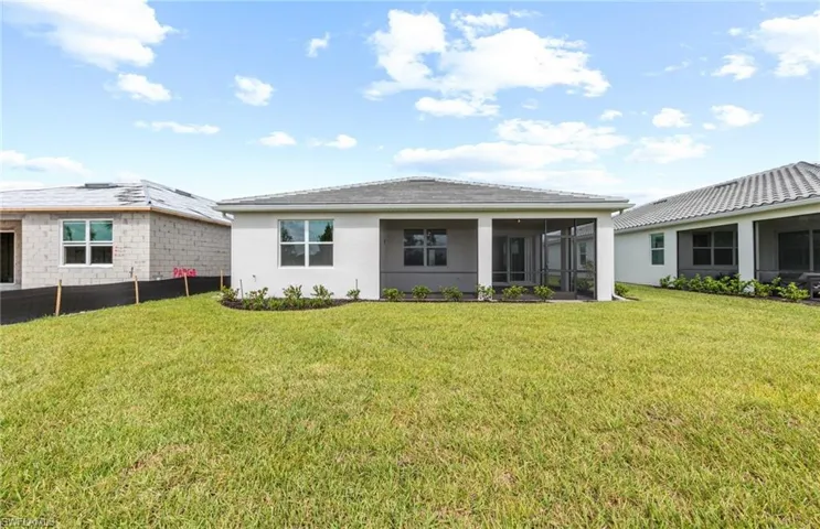 Back of property with a lawn and a sunroom