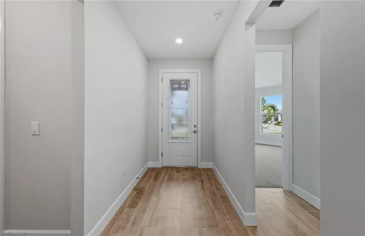 Doorway featuring a healthy amount of sunlight and light hardwood / wood-style floors