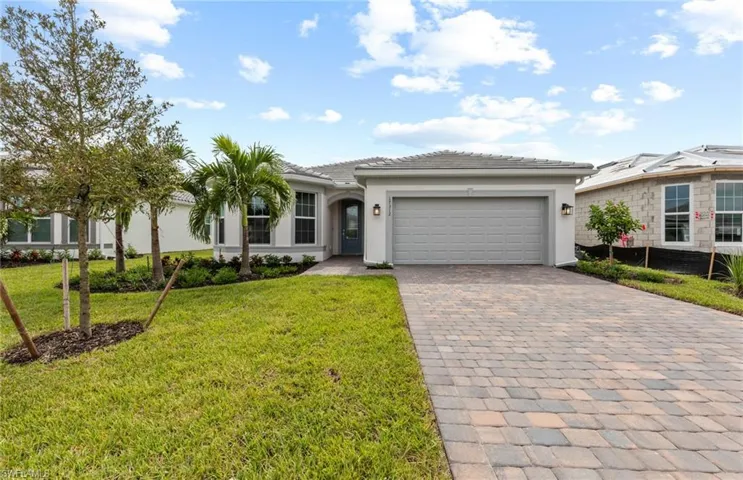 View of front facade featuring a front yard and a garage