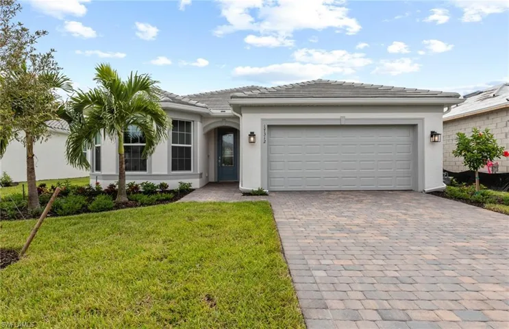 View of front of home with a garage and a front lawn