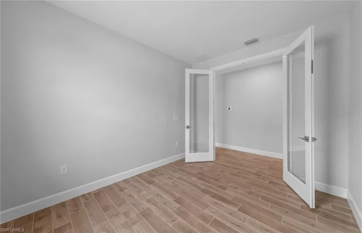 Unfurnished bedroom with light hardwood / wood-style flooring and french doors