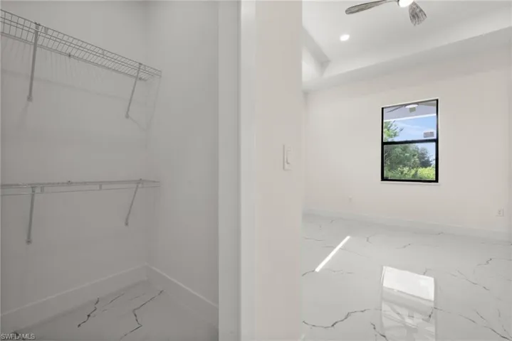 Spacious closet featuring marble finish flooring