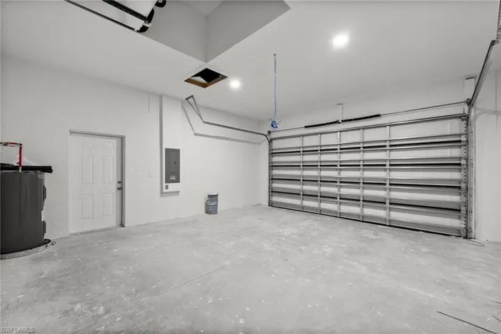 Garage featuring electric panel and water heater