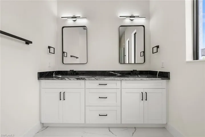 Bathroom with marble finish flooring and double vanity