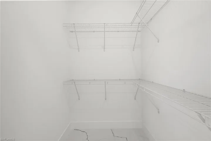 Spacious closet with light marble finish floors