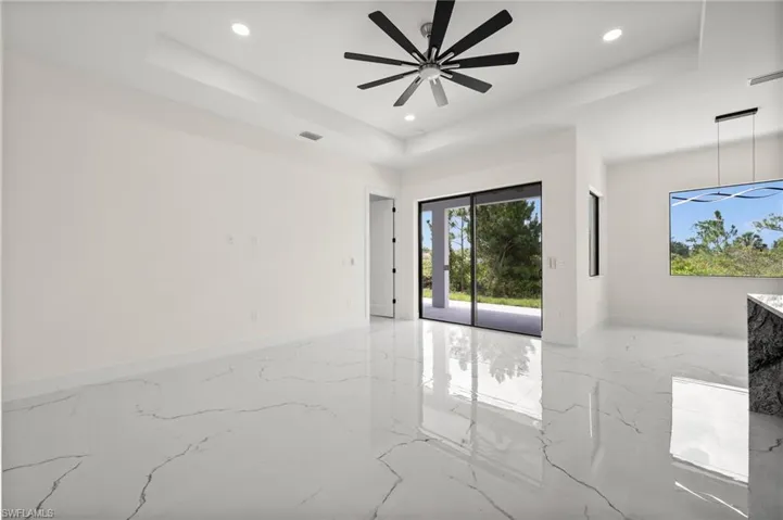 Spare room with recessed lighting, a raised ceiling, marble tiled floors, and ceiling fan