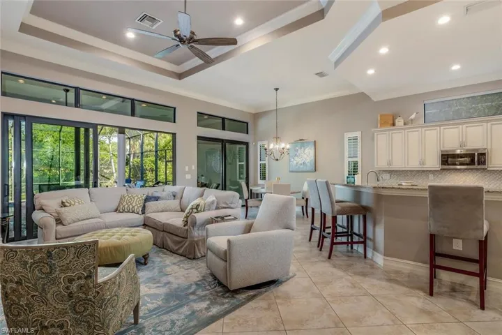 Great Room with light tile patterned floors, ornamental molding, volume ceilings, recessed lighting