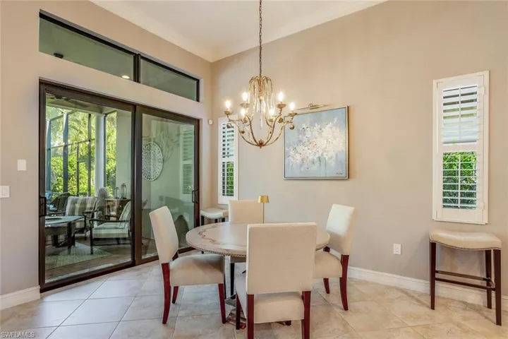 Dining room with a chandelier, light tile patterned floors, sliding glass doors to lanai