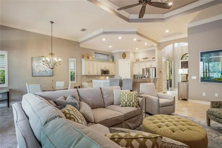 Living room with natural light, light tile patterned floors, a ceiling fan, recessed lighting, and ornamental molding