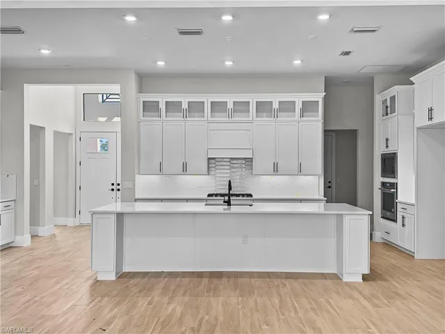 Kitchen includes upgraded cabinets with upper cabinets for additional storage and a beautifully finished look. Calcutta Gold quartz countertops, extra large sink, NATURAL GAS cooktop, and beverage service area.