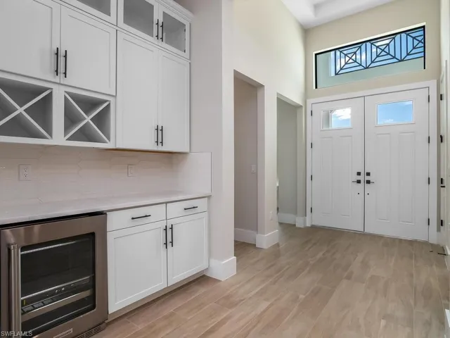 Built-in Beverage cooler and service bar with wine storage, additional cabinetry, and upper cabinets make this the perfect space for a coffee or mixing bar area.