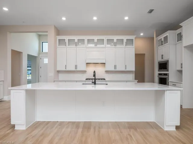 Kitchen includes upgraded cabinets with upper cabinets for additional storage and a beautifully finished look. Calcutta Gold quartz countertops, extra large sink, NATURAL GAS cooktop, and beverage service area.