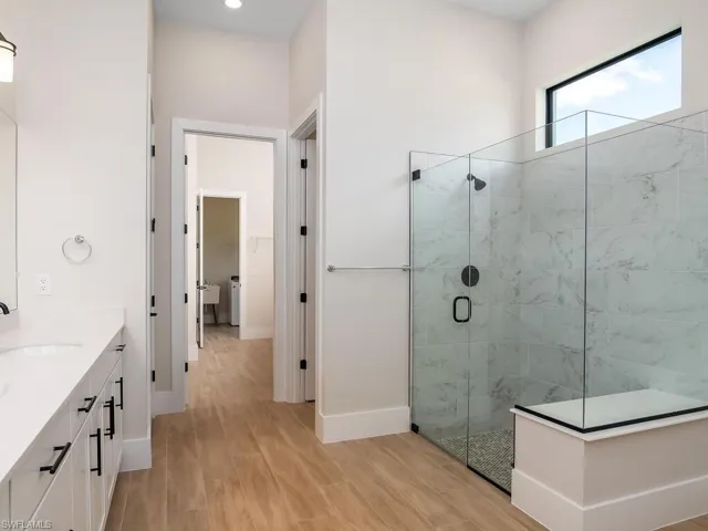 Primary bathroom includes large walk-in shower with frameless glass enclosure.