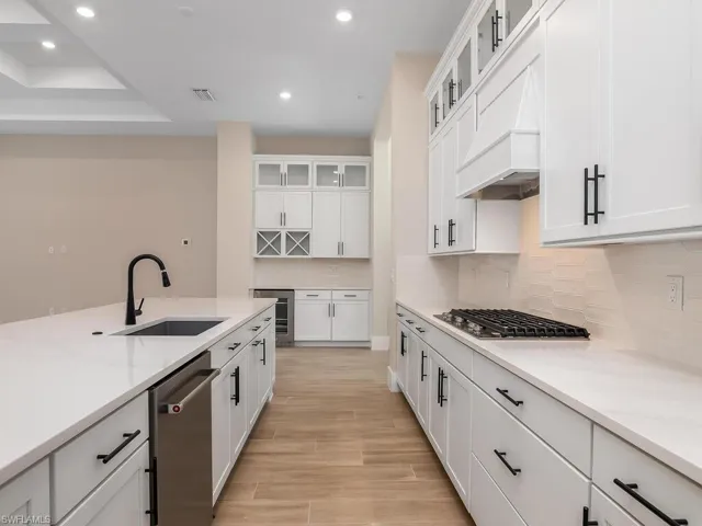 Oversize kitchen island with Calcutta gold quartz and beautiful cabinetry and fixtures.