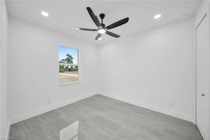Empty room with a ceiling fan and recessed lighting