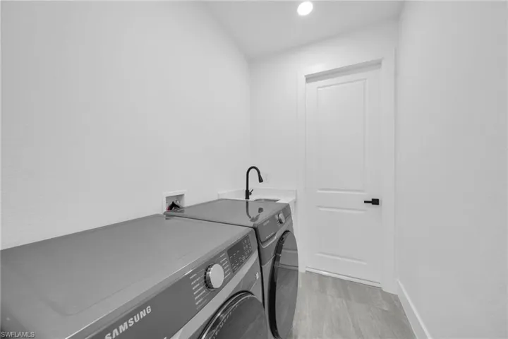 Laundry area featuring washer and dryer, recessed lighting, and light wood finished floors
