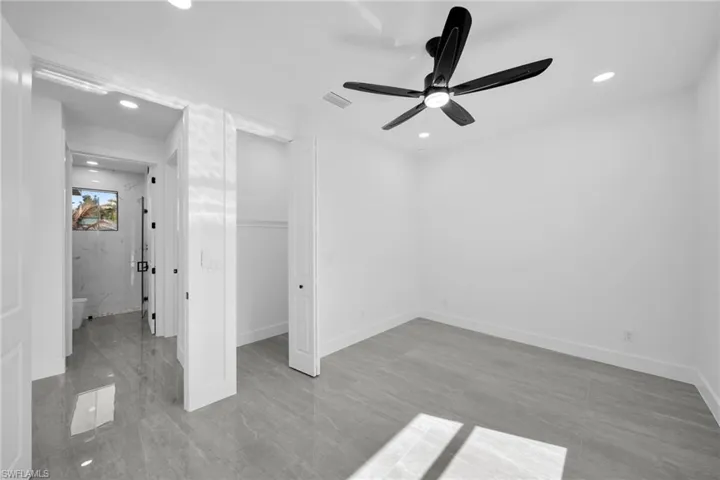 Unfurnished bedroom featuring a walk in closet, recessed lighting, and a ceiling fan