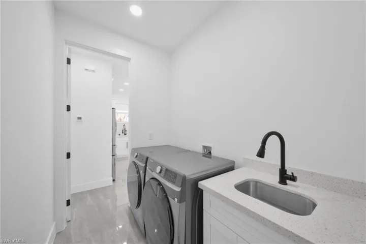 Laundry room featuring independent washer and dryer and recessed lighting