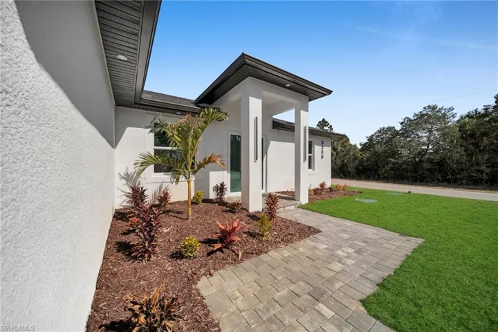 View of side of home featuring a yard and stucco siding