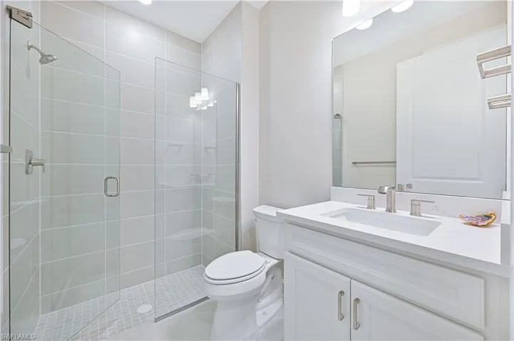 Full bathroom with vanity, a shower stall, and light tile patterned flooring