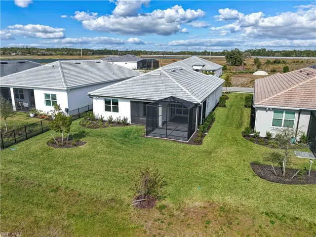 Back of property featuring stucco siding, glass enclosure, a sunroom, and a fenced backyard